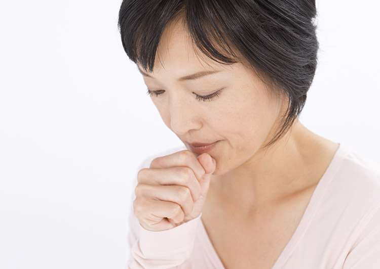 咳をする女性のイメージ写真